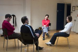 Four actors sitting North, South, East and Wes facing towards each other