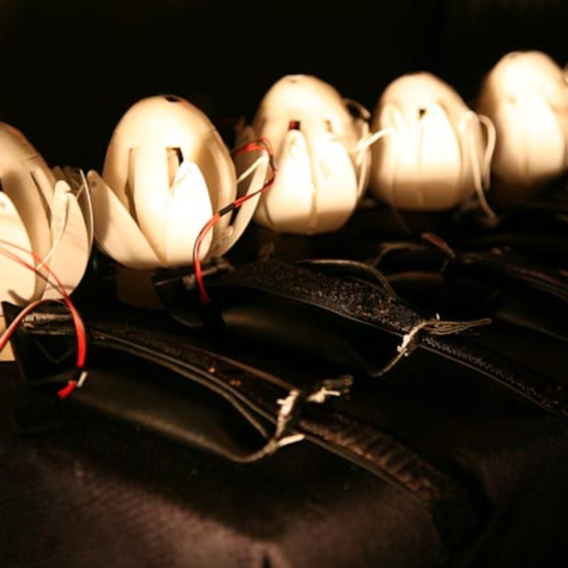 A row of six haptic lotuses - robotic devices - are glowing in the dark