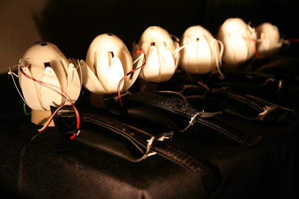 A row of six haptic lotuses - robotic devices - are glowing in the dark