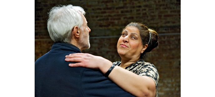 An older man and woman pictured from the shoulders up in ballroom hold