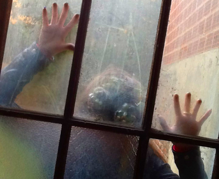 Zombie with hands pressed against glass door