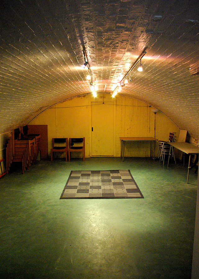 Interior of the Putney arches performance space, domed ceiling with simple lighting rig - laid out with carpet and chairs stacked either side