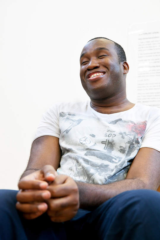 Another young man sits relaxed and smiling