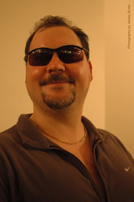 Gary, wearing sunglasses, smiles at the camera