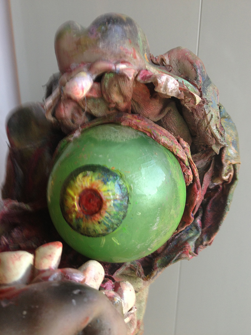 Close up of zombie eye prosthetic surrounded by teeth