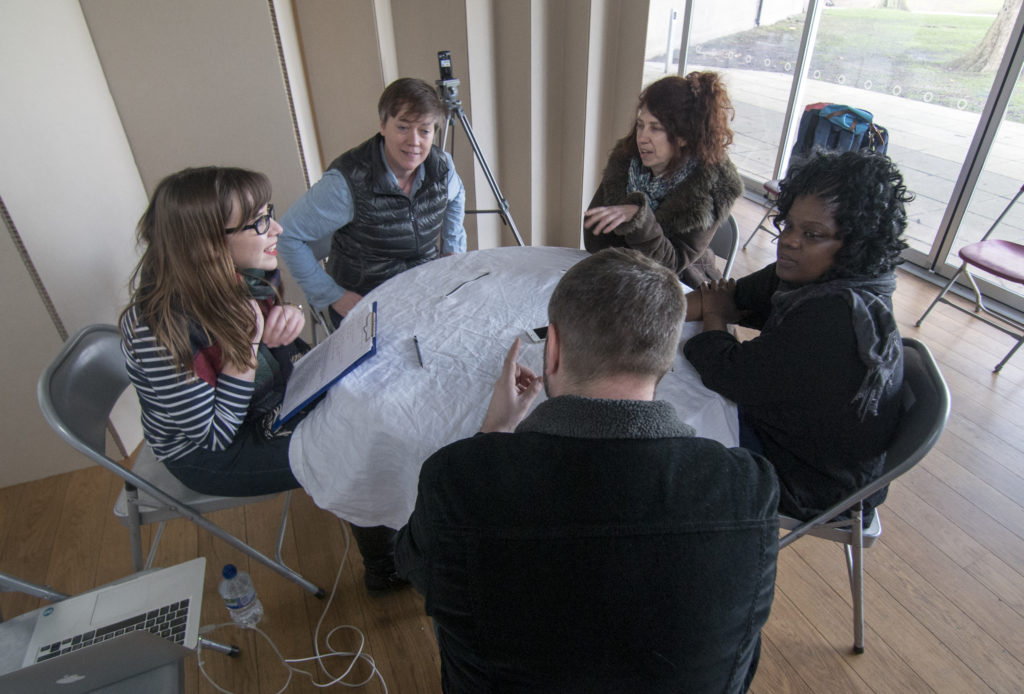 Pic from Flatland project dissemination - group of six people sitting around a table for evaluation and discussion