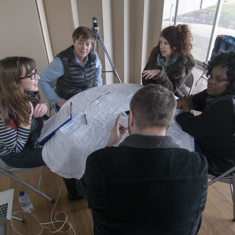 Pic from Flatland project dissemination - group of six people sitting around a table for evaluation and discussion