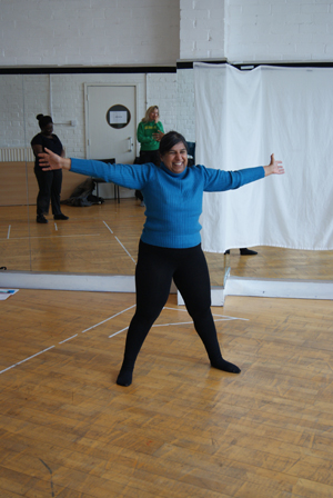 Woman stands with arms and legs stretched out