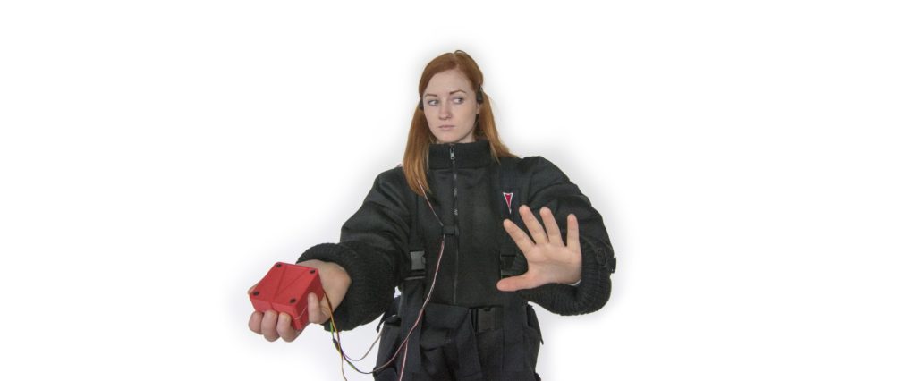 A woman holds a red cube in one hand