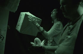 Photo from 'The Question' using a night-vision camera showing a participant holding a box