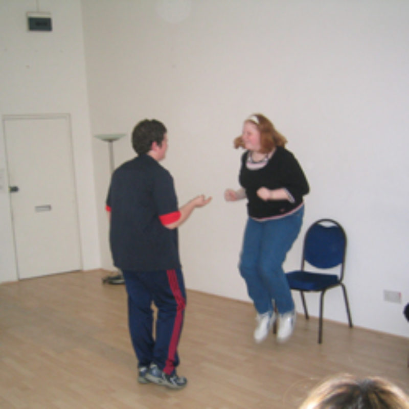 A white boy and girl use a skipping rope in a dance studio. Film of participation work