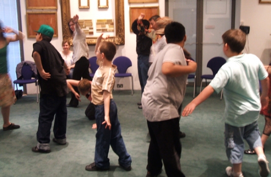 Young people move around in a circle as part of a warming up exercise