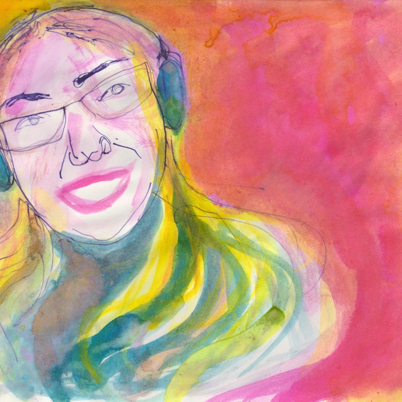 A Director is laughing out loud, her face has a wide smile. She has glasses and large headphones, and long fair hair drapes over her shoulders. The colours are bright and cheery pinks and yellows