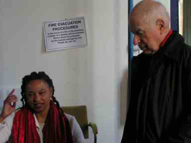 Peter Brook, standing, watches the production team discussing the rehearsal