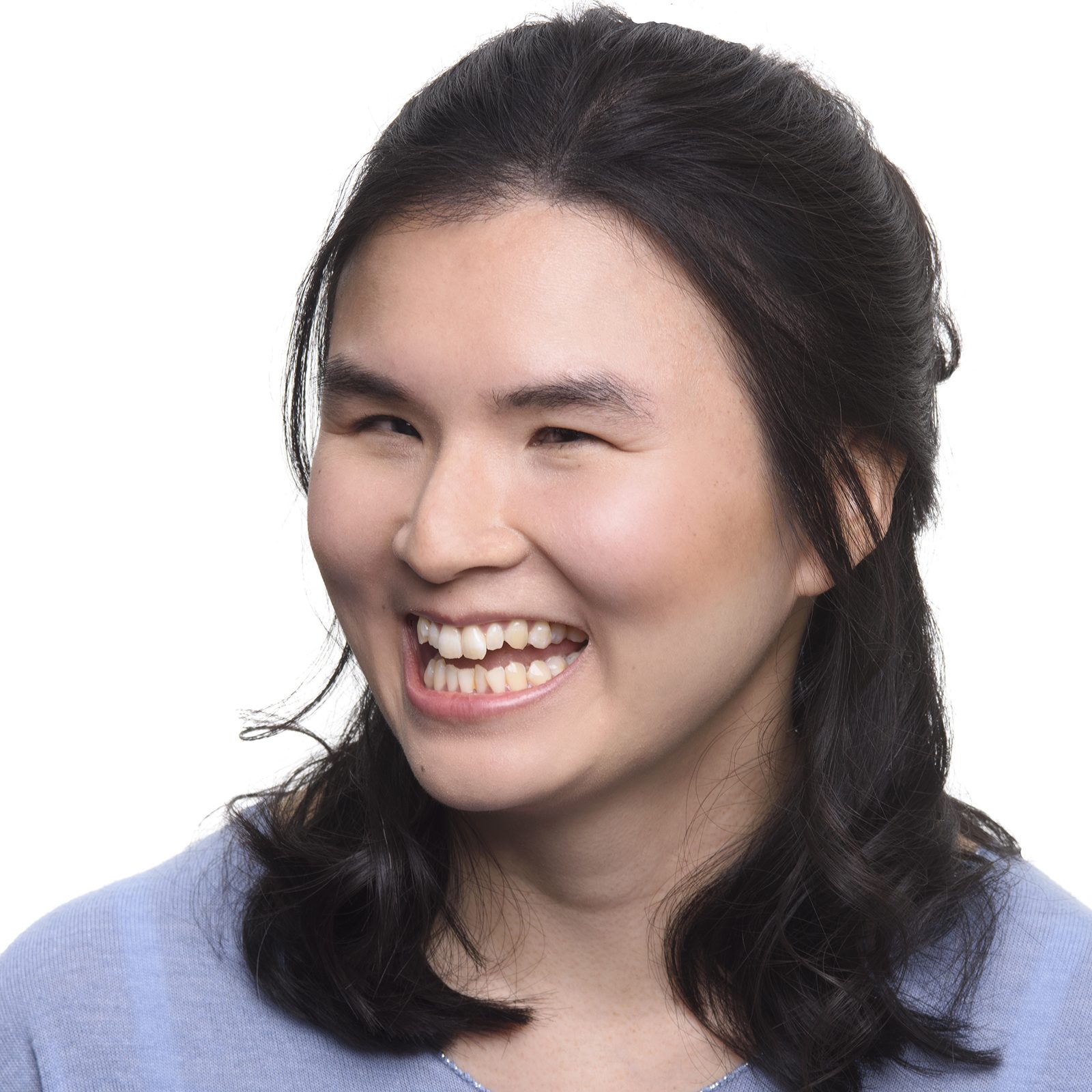 Headshot of Jasmin, a young Chinese Actress with long straight black hair. She is wearing a lilac top looking at the camera with a laughing smile.