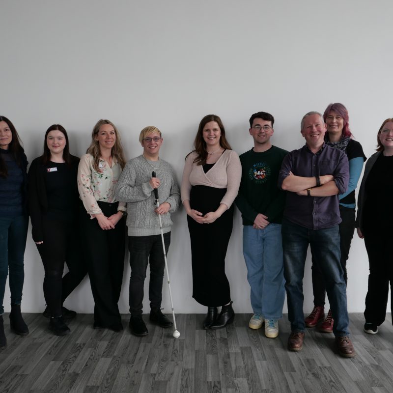 A group of Courtyard Hereford staff members standing in a line posing for a photo with Anthony, Post-Enhance VI facilitator.