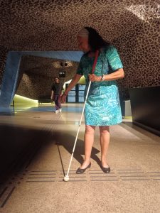 A side shot of Maria pointing out tactile flooring.
