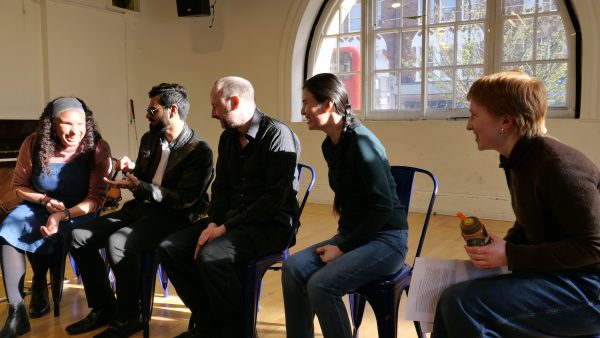 5 members of the creative team are sat in a line for the Q/A. From left to right: Maria, Shashank, Chris, Jasmine and Grace. They are smiling and laughing. Light from the window shines on them.