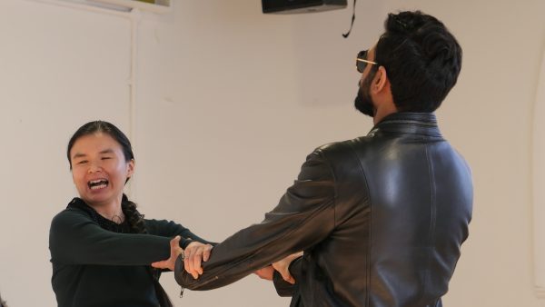 Jasmine and Shashank hold onto each other's arms and stretch outwards.